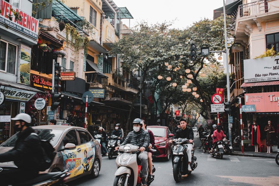 Dynamic street scene in Hanoi, Vietnam, showcasing motorbikes and vibrant city life.