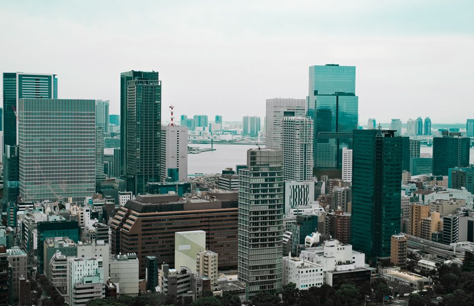 Aerial view of Tokyo's modern skyscrapers with a river backdrop, showcasing urban architecture.