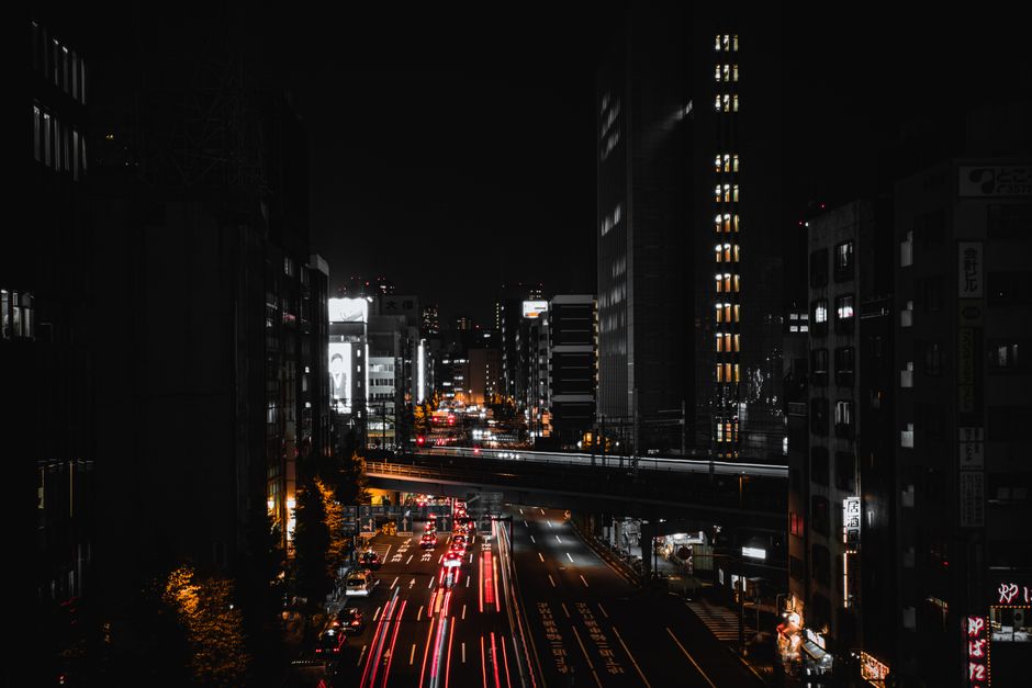 Aerial view of Tokyo city at night showcasing light trails and skyscrapers.