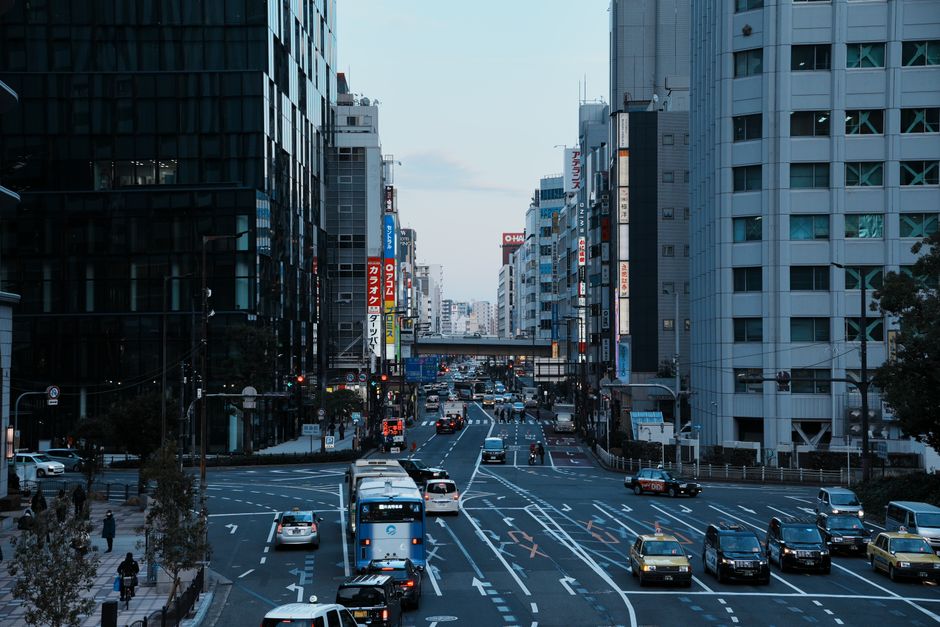 Vibrant cityscape of a busy Tokyo street filled with traffic and pedestrians, showcasing urban Japanese life.