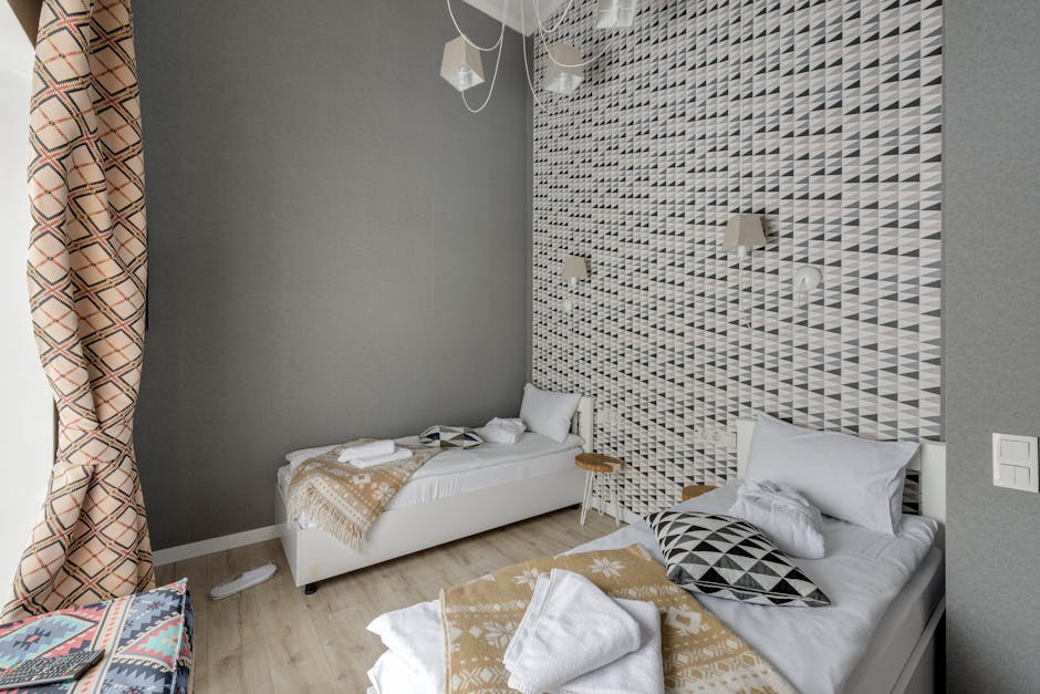 Stylish hotel room featuring modern geometric wallpaper and elegant interior design.