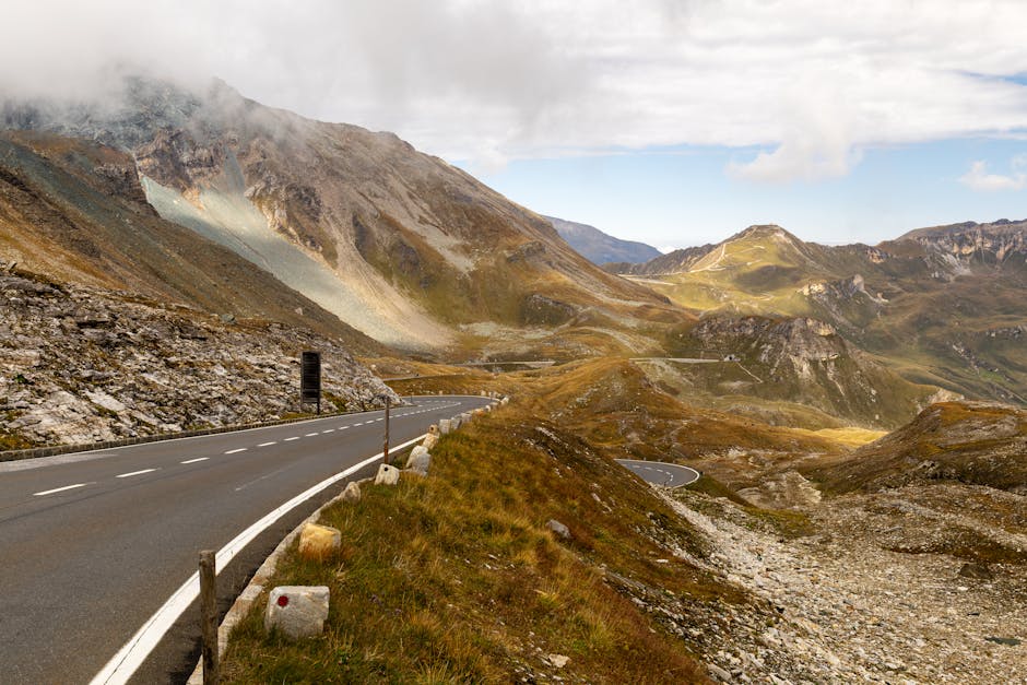 A winding mountain road in Hochtor, Austria, with stunning views of peaks and valleys.