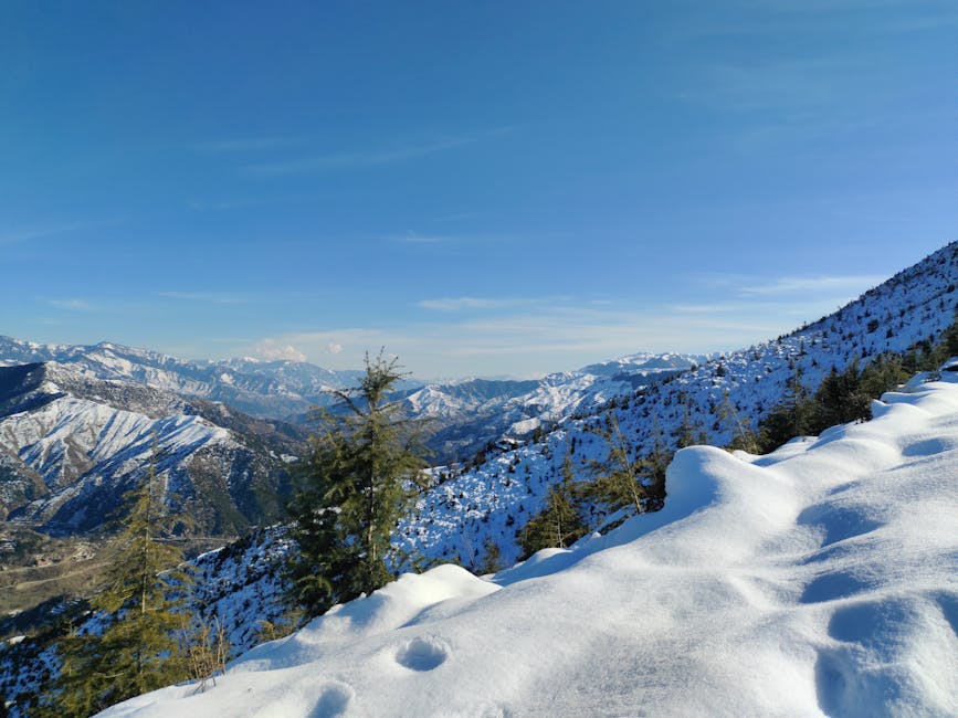 Captivating view of snow-covered mountains under a clear blue sky, perfect for winter travel inspiration.