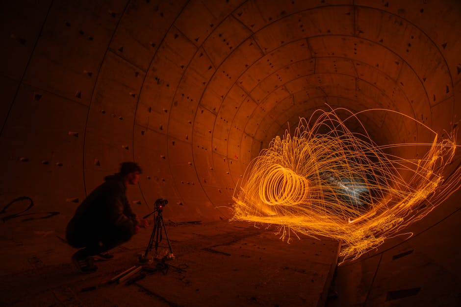 Captivating long exposure of light painting in an urban tunnel, showcasing vibrant sparks and artistic motion.