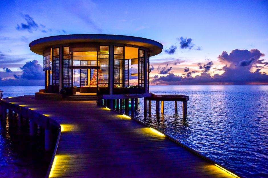 Beautiful round pavilion on a pier overlooking the tranquil sea at sunset.