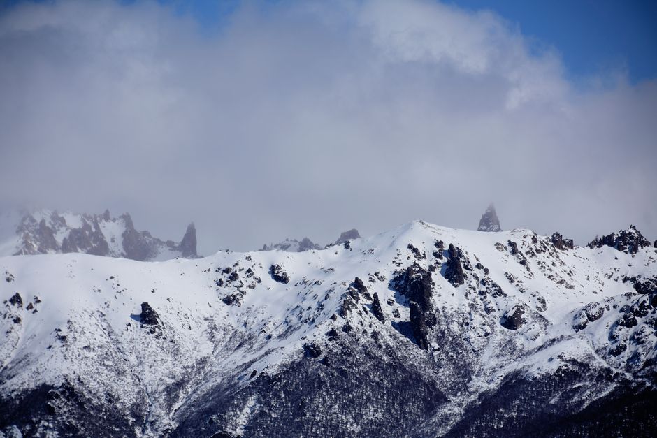 Captivating snowy peaks of the Andes in Bariloche, Argentina, under a cloudy sky.