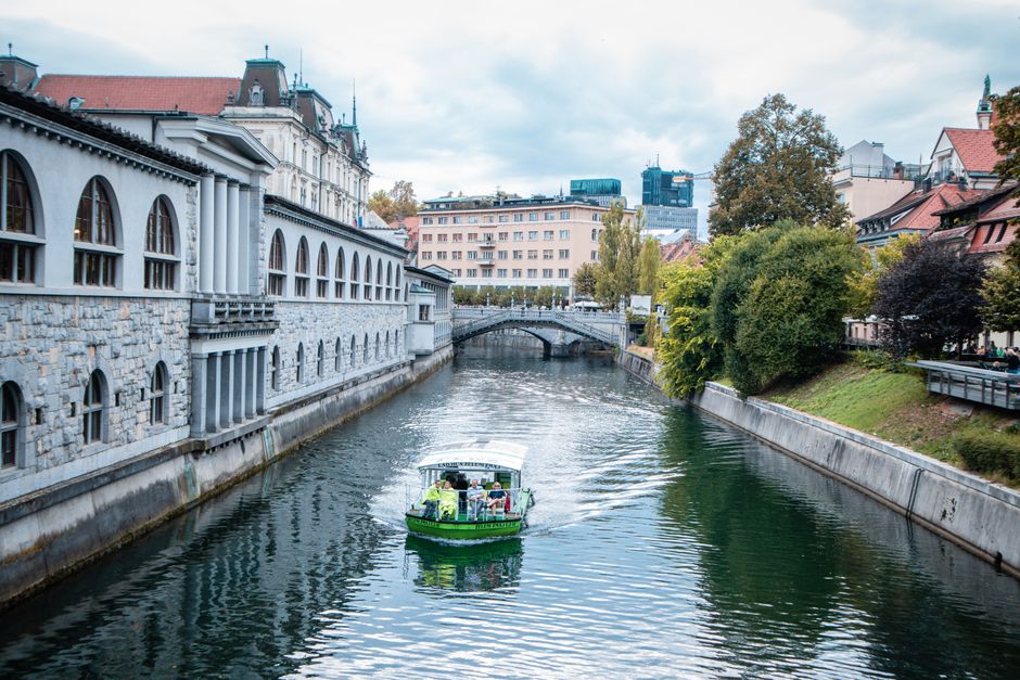 Explore a scenic view of a canal with a boat in Ljubljana, Slovenia.