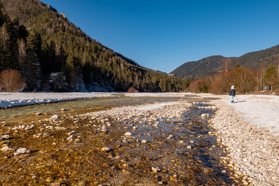 Scenic winter view of a river and mountains in Kranjska Gora, Slovenia.