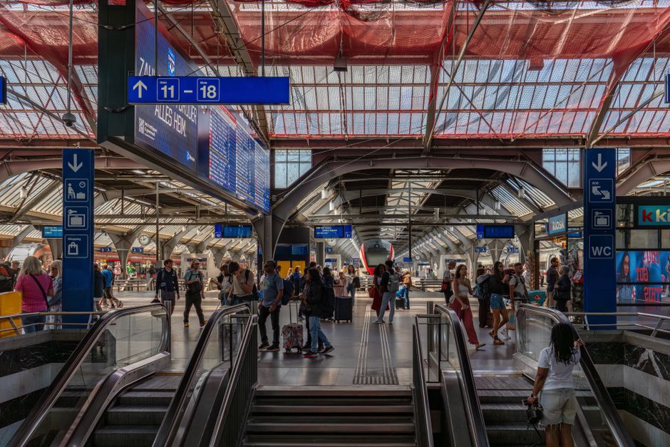 A bustling train station with commuters and signage, capturing urban transit life.