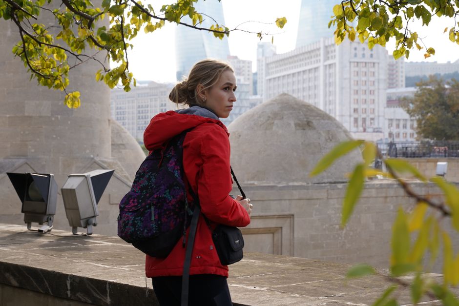 A woman in Baku with the Flame Towers in the background, capturing the city's essence.