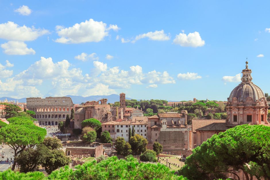A stunning vista of the Colosseum and historic Roman buildings under a clear blue sky.